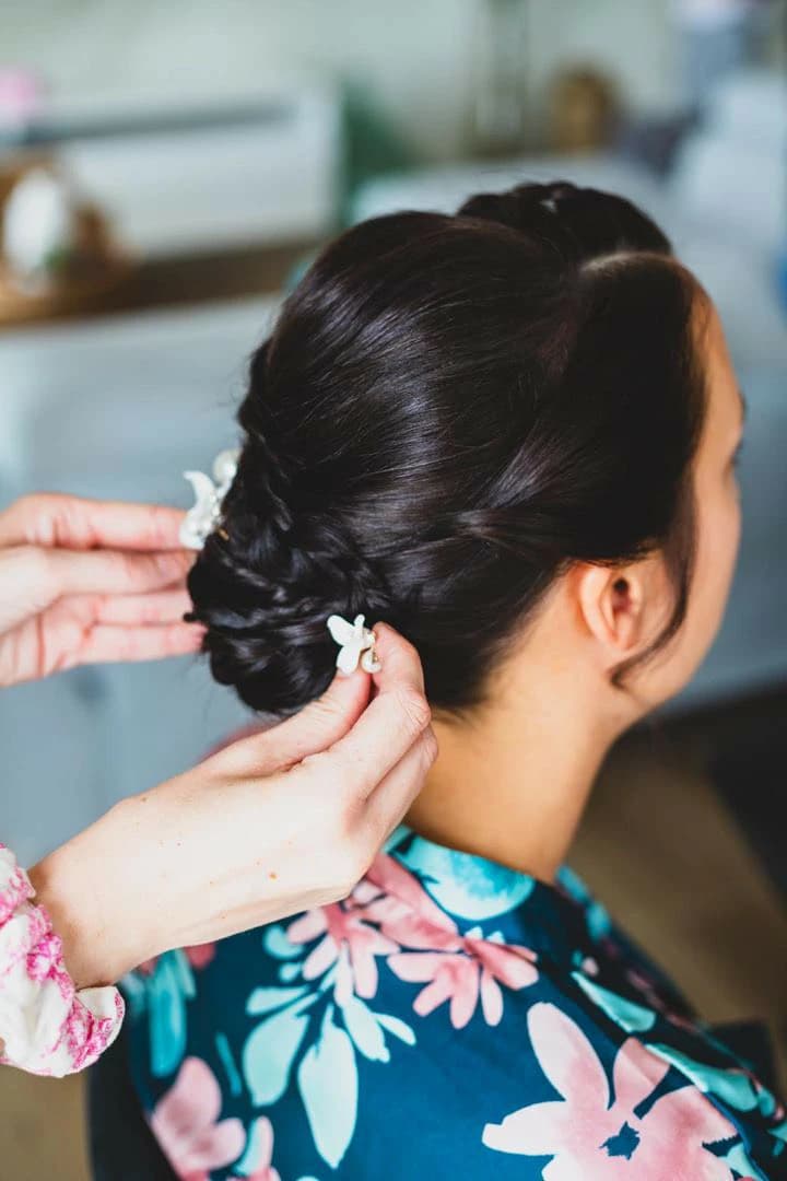 Finition d'un chignon de mariée avec soin pour un jour inoubliable.
